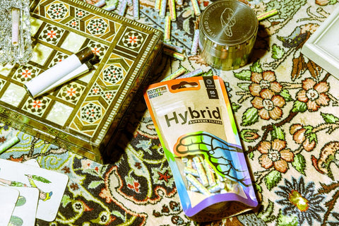 Hybrid Supreme Filter Bag Kunter Bunt mit 55 Filtertips, Clipper, Edelstahl Grinder und gedrehter Zigarette auf Tisch