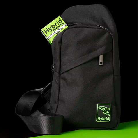 Schwarze Hybrid Crossbody-Sling-Bag mit Hybrid Kombipack Filter und Rolls im Fronttaschenfach, grünes Logo-Patch, grüner Hintergrund
