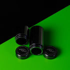 Zwei schwarze Hybrid Supreme Filters Aufbewahrungsdosen für Herbs liegend geöffnet, daneben die beiden Schraubdeckel mit silbernem Logo und Schriftzug "EST. 2020 I VIE".