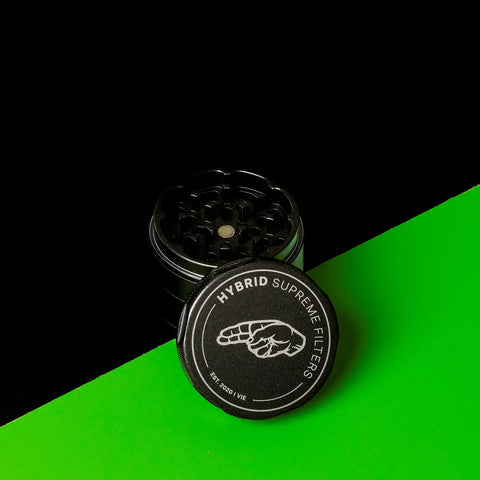 Schwarzer Keramik Grinder Hybrid mit abgenommenem Deckel, Logo sichtbar im Vordergrund.