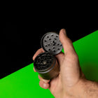 Keramik Grinder Hybrid in der Hand gehalten, Deckel geöffnet und Mahlzähne sichtbar.