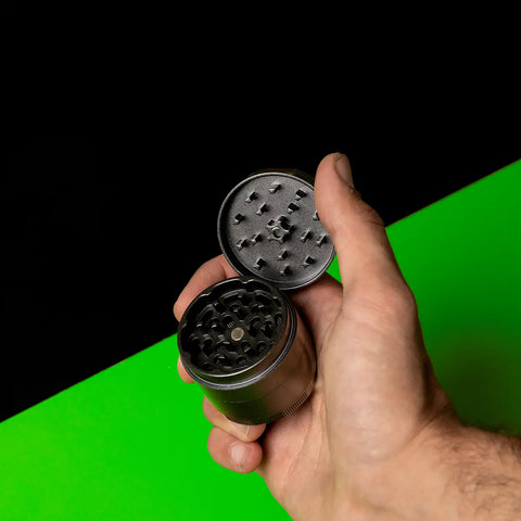 Keramik Grinder Hybrid in der Hand gehalten, Deckel geöffnet und Mahlzähne sichtbar.