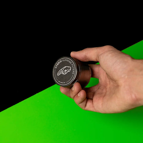 Keramik Grinder Hybrid in der Hand, geschlossener Logo-Deckel gut sichtbar.