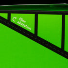 Detailaufnahme der perforierten Aufreißlinie am Hybrid Umkarton mit weißem Hinweis "Hier abziehen" und Pfeil-Symbol auf neongrünem Karton.